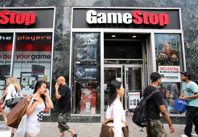 outside view of a GameStop building with people walking in front of it